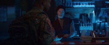 Movie still from “VFW” (2019), directed by Joe Begos – A man is sitting at a counter in front of another man; Medium shot, Over the shoulder angle