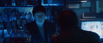 Movie still from “VFW” (2019), directed by Joe Begos – An older man is talking to a younger man in a dark room; Medium shot, Over the shoulder angle