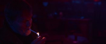 Movie still from “VFW” (2019), directed by Joe Begos – A person holding a lit candle in a dark room; Close Up shot, Over the shoulder angle