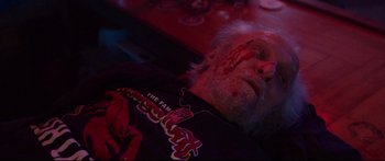 Movie still from “VFW” (2019), directed by Joe Begos – An old man with a beard and a bloody face; Close Up shot, Overhead angle