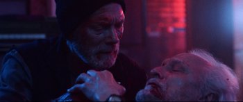 Movie still from “VFW” (2019), directed by Joe Begos – A man with a beard is holding another man's hand; Close Up shot, Over the shoulder angle