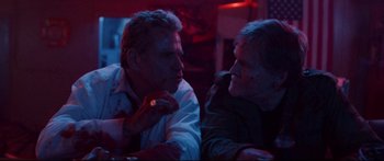 Movie still from “VFW” (2019), directed by Joe Begos – Two men sitting next to each other in a dark room; Close Up shot, Over the shoulder angle