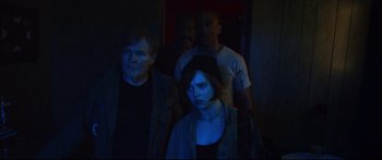 Movie still from “VFW” (2019), directed by Joe Begos – A group of people standing in the dark; Medium shot, Over the shoulder angle