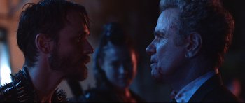 Movie still from “VFW” (2019), directed by Joe Begos – Two men and a woman face to face in a dark room; Close Up shot, Over the shoulder angle