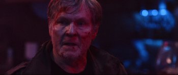 Movie still from “VFW” (2019), directed by Joe Begos – An older man with a bloody face and red paint on his face; Close Up shot, Over the shoulder angle