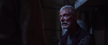 Movie still from “VFW” (2019), directed by Joe Begos – An older man with a bloody face stares into a mirror; Close Up shot, Over the shoulder angle