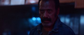 Movie still from “VFW” (2019), directed by Joe Begos – A person wearing a jean jacket; Close Up shot, Low angle