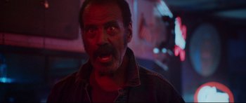 Movie still from “VFW” (2019), directed by Joe Begos – An older man with a beard and mustache is looking at the camera; Close Up shot, Low angle