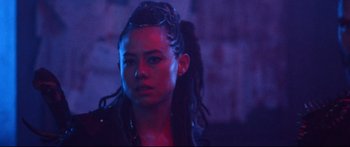 Movie still from “VFW” (2019), directed by Joe Begos – A person with dreadlocks in a dark room; Close Up shot, Low angle