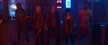 Movie still from “VFW” (2019), directed by Joe Begos – A group of people standing next to each other in a room; Wide shot, Low angle