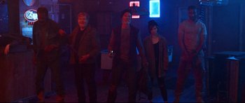 Movie still from “VFW” (2019), directed by Joe Begos – A group of people standing in a dark room; Wide shot, High angle