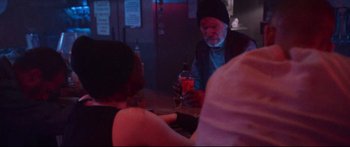 Movie still from “VFW” (2019), directed by Joe Begos – An older man sitting at a bar with a drink; Medium shot, Over the shoulder angle