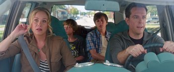 Movie still from “Vacation” (2015), directed by John Francis Daley – A group of people sitting in the back of a car; Medium shot, Over the shoulder angle