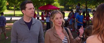 Movie still from “Vacation” (2015), directed by John Francis Daley – A woman standing next to a man in front of a group of people; Medium shot, Over the shoulder angle