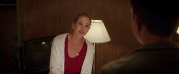 Movie still from “Vacation” (2015), directed by John Francis Daley – A woman sitting in front of a lamp in a dimly - lit room; Medium shot, Over the shoulder angle