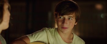 Movie still from “Vacation” (2015), directed by John Francis Daley – A young man is looking at the camera while holding a guitar; Close Up shot, Over the shoulder angle
