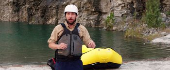 Movie still from “Vacation” (2015), directed by John Francis Daley – A man wearing a life jacket next to an inflatable raft; Wide shot, High angle