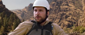 Movie still from “Vacation” (2015), directed by John Francis Daley – A man with a white helmet on a mountain side; Close Up shot, Over the shoulder angle