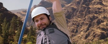 Movie still from “Vacation” (2015), directed by John Francis Daley – A man wearing a hard hat while holding his arm up; Medium shot, Overhead angle