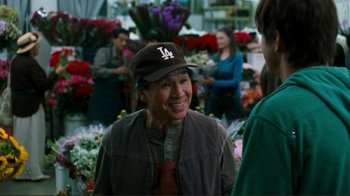 Movie still from “Valentine's Day” (2010), directed by Garry Marshall – An older woman wearing a baseball hat and vest; Medium shot, Over the shoulder angle