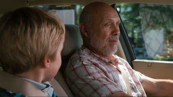 Movie still from “Valentine's Day” (2010), directed by Garry Marshall – An older man sitting in the back of a car with a young boy; Close Up shot, Over the shoulder angle