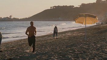 Movie still from “Valentine's Day” (2010), directed by Garry Marshall – Two people running on the beach near the water; Wide shot, Over the shoulder angle