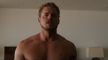 Movie still from “Valentine's Day” (2010), directed by Garry Marshall – A man with a tattoo is standing in front of a wall; Close Up shot, Low angle