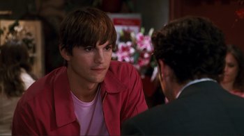 Movie still from “Valentine's Day” (2010), directed by Garry Marshall – A man sitting in front of another man in front of flowers; Close Up shot, Over the shoulder angle