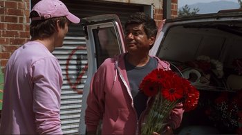 Movie still from “Valentine's Day” (2010), directed by Garry Marshall – A man holding a bouquet of flowers in front of another man; Medium shot, Over the shoulder angle