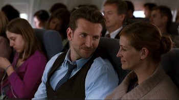 Movie still from “Valentine's Day” (2010), directed by Garry Marshall – A man and a woman sitting next to each other on a plane; Medium shot, Over the shoulder angle