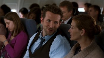 Movie still from “Valentine's Day” (2010), directed by Garry Marshall – A man and a woman sitting next to each other on a plane; Medium shot, Over the shoulder angle