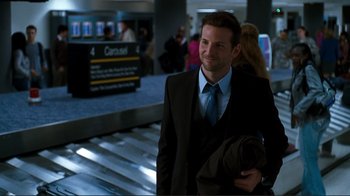 Movie still from “Valentine's Day” (2010), directed by Garry Marshall – A man in a suit and tie at an airport; Medium shot, Over the shoulder angle