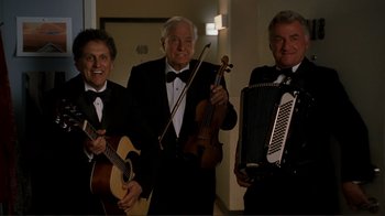 Movie still from “Valentine's Day” (2010), directed by Garry Marshall – A group of men in tuxedos holding musical instruments; Medium shot, Low angle