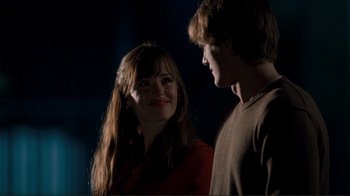 Movie still from “Valentine's Day” (2010), directed by Garry Marshall – A young man and a young woman standing next to each other in the dark; Medium shot, Over the shoulder angle