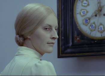 Movie still from “Valerie and Her Week of Wonders” (1970), directed by Jaromil Jires – A woman with blonde hair is looking at a clock; Close Up shot, Low angle