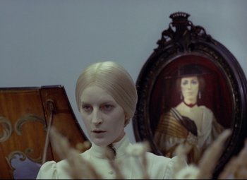 Movie still from “Valerie and Her Week of Wonders” (1970), directed by Jaromil Jires – A woman in a white dress is in front of a painting; Close Up shot, Over the shoulder angle