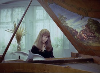 Movie still from “Valerie and Her Week of Wonders” (1970), directed by Jaromil Jires – A woman sitting in front of a grand piano in a room; Medium shot, High angle