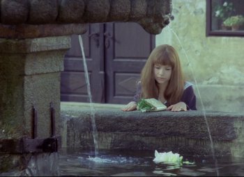 Movie still from “Valerie and Her Week of Wonders” (1970), directed by Jaromil Jires – A girl is reading a book near a fountain; Medium shot, High angle