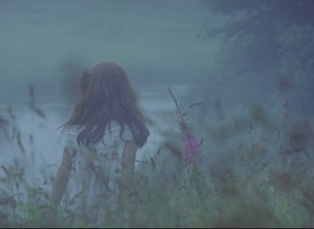 Movie still from “Valerie and Her Week of Wonders” (1970), directed by Jaromil Jires – A woman standing in tall grass near a body of water; Medium shot, Over the shoulder angle