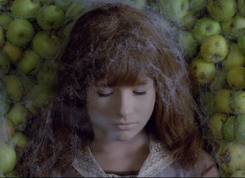 Movie still from “Valerie and Her Week of Wonders” (1970), directed by Jaromil Jires – A woman with her eyes closed in front of a bunch of apples; Close Up shot, Overhead angle