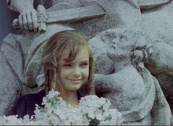 Movie still from “Valerie and Her Week of Wonders” (1970), directed by Jaromil Jires – A young girl is posing in front of a statue; Close Up shot, High angle