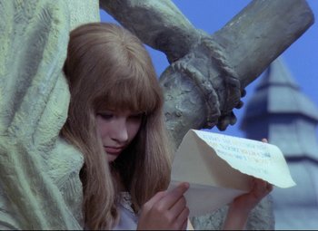Movie still from “Valerie and Her Week of Wonders” (1970), directed by Jaromil Jires – A girl is reading a letter in front of a statue; Medium shot, High angle