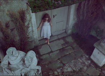 Movie still from “Valerie and Her Week of Wonders” (1970), directed by Jaromil Jires – A little girl standing in front of an open door; Wide shot, Overhead angle
