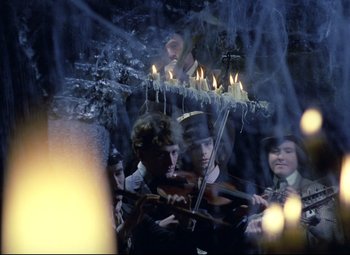 Movie still from “Valerie and Her Week of Wonders” (1970), directed by Jaromil Jires – A group of people playing music with candles on top of them; Medium shot, High angle