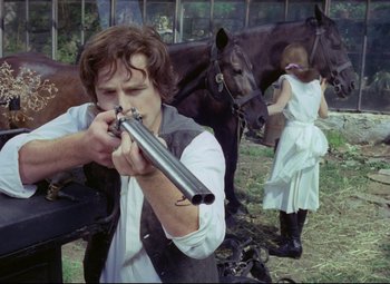 Movie still from “Valerie and Her Week of Wonders” (1970), directed by Jaromil Jires – A man holding a gun while standing next to a horse; Medium shot, Over the shoulder angle