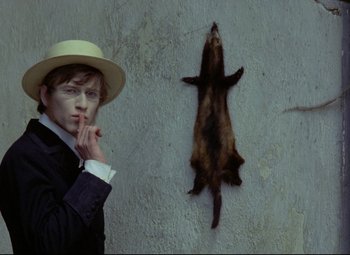 Movie still from “Valerie and Her Week of Wonders” (1970), directed by Jaromil Jires – A man in a suit and hat next to a dead animal; Medium shot, Over the shoulder angle