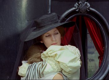 Movie still from “Valerie and Her Week of Wonders” (1970), directed by Jaromil Jires – A woman wearing a black hat and holding a white dress; Medium shot, Over the shoulder angle