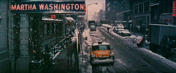 Movie still from “Valley of the Dolls” (1967), directed by Mark Robson – A yellow taxi cab driving down a street in the snow; Extreme Wide shot, High angle