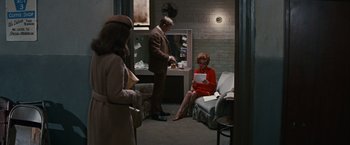 Movie still from “Valley of the Dolls” (1967), directed by Mark Robson – A man and a woman sitting on a couch in a room; Wide shot, High angle