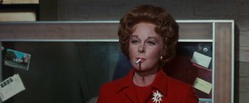 Movie still from “Valley of the Dolls” (1967), directed by Mark Robson – An older woman in a red dress smoking a cigarette; Close Up shot, Low angle